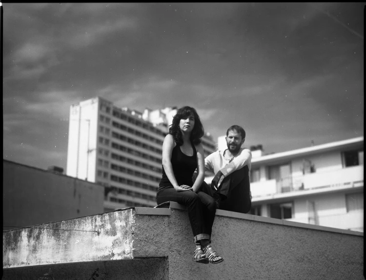 Un homme et une femme assis sur le toit d'un bâtiment moderne