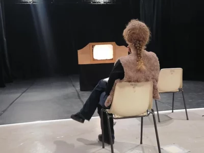 Photo de scène du spectacle Le loup de Marlaguette: une femme assise de deux regarde un écran en carton