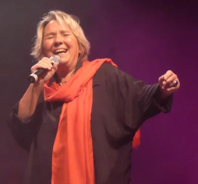 Martine Scozzesi, chanteuse, en traind e chanter sur un fond violet