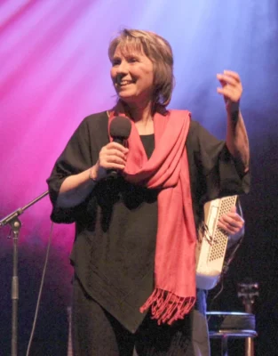 La chanteuse Martine Scozzesi sur scène avec un micro à la main