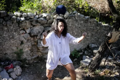 Une femme avec une chemise blanche en pleine nature en train de parler