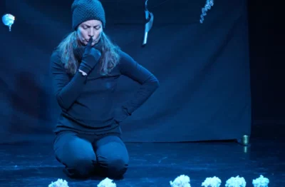 La comédienne et chanteuse Stéphanie Joire habillée en noir, assis sur scène en train de jouer