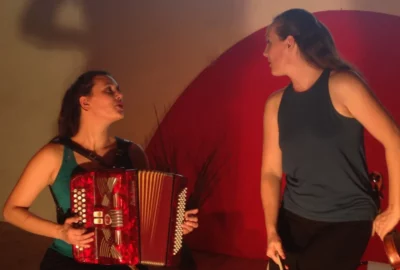 Deux femmes sur scène se regardent, l'une d'entre elles joue un accordéon