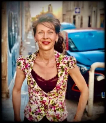 La chanteuse et percussioniste Julie Ettabaâ sourit devant l'objectif, dans une rue