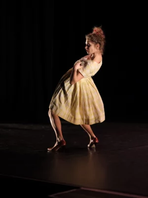 Une des interprètes du spectacle de théâtre-danse Farmor Mamita en train de danser sur une scène noir