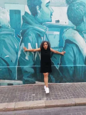 L'interprète Sophie Clodion pose en extérieur sur le fond d'un murale