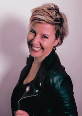 Rockie Paillettes, chanteuse et compositrice, sourit à l'appareil photo