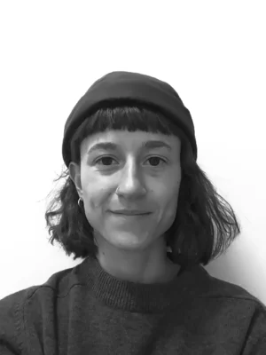 Portrait en noir et blanc d'une jeune femme souriante avec un bonnet 