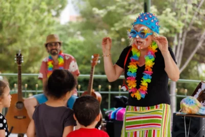 La chanteuse Sabine Pey devant un public d'enfant et derrière elle le musicien Fabien Canetto qui l'accompagne dans le spectacle Ramène ta fraise