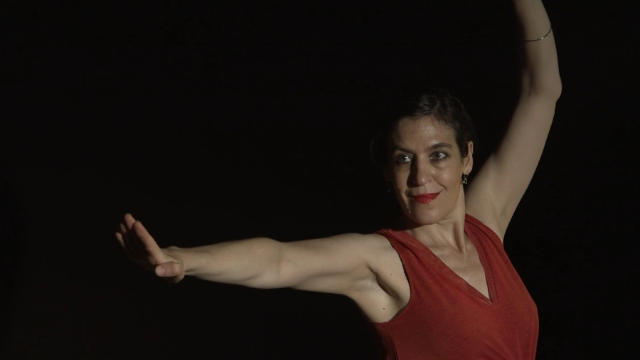 Photo de la danseuse et comédienne Ofra Hoffmann en mouvement sur un fond noir