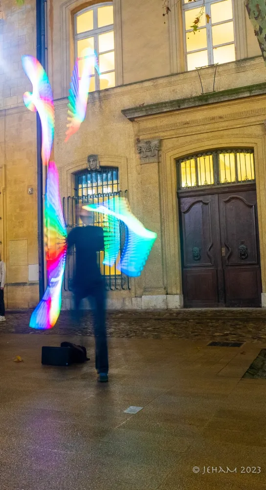 Edith Godefroid, comédienne, jongle avec des massues lumineuse dans la rue