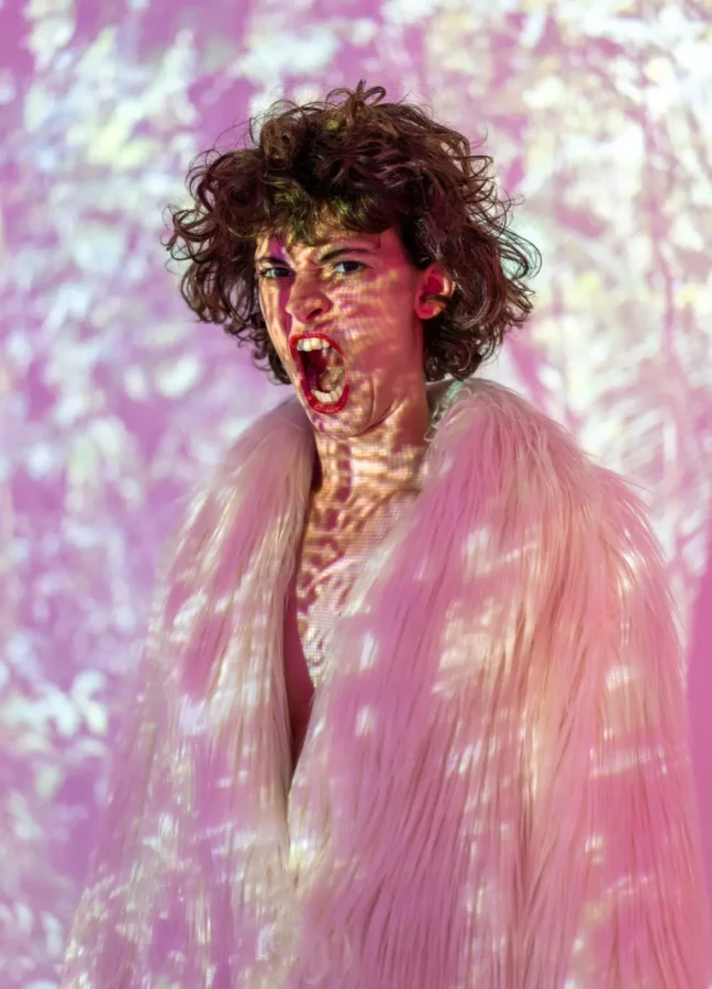 La chorégraphe et interprète Céline Bellut sur scène, en train de crier et avec des images projetées sur son corps