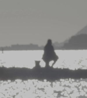 Photo en noir et blanc d'une silhouette de dos qui regarde vers la mer