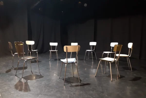 Un cercle de chaises vide sur un plateau de théâtre