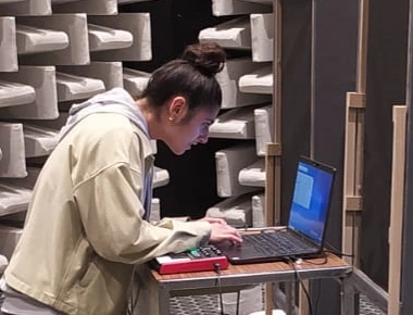 Une jeune femme de profil en train de travailler à l'ordinateur