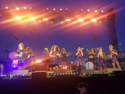 Sur un scène des spectacle, des musiciennes sont en train de jouer devant un public