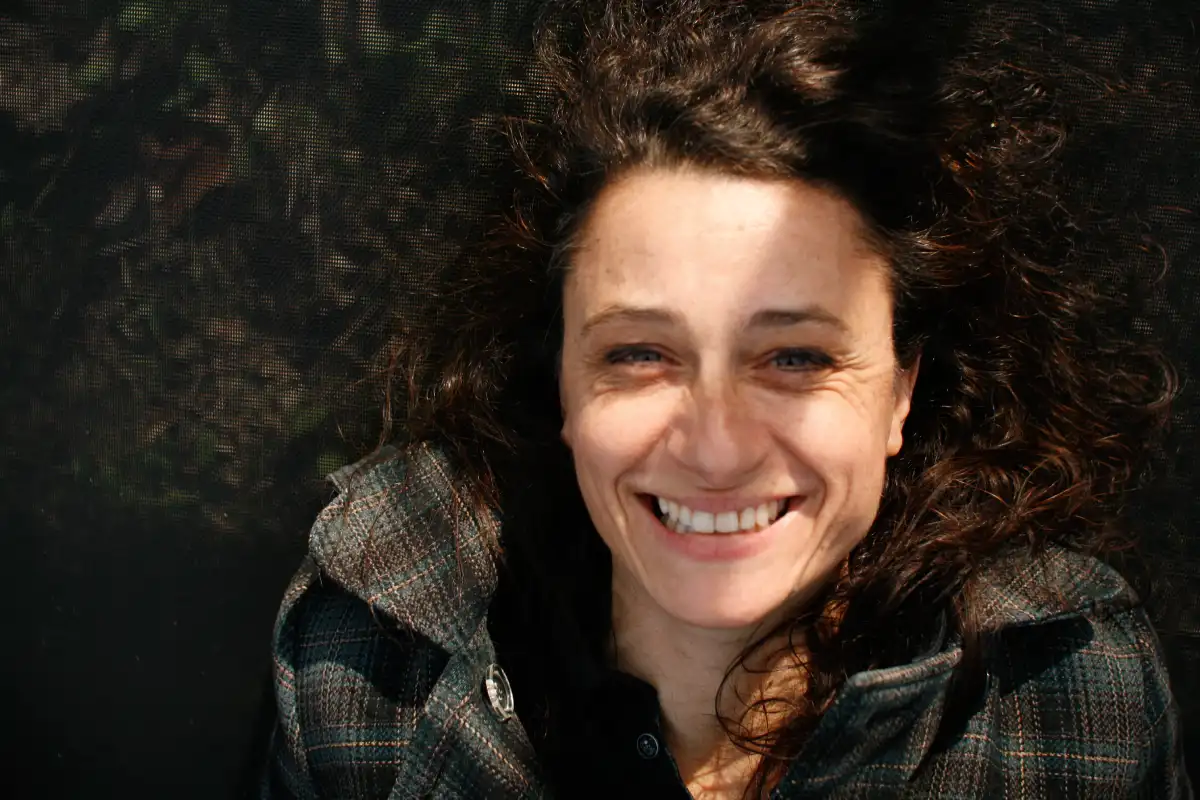 Une femme souriante sur fond sombre