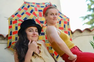 Deux femmes assise en extérieur à l'ombre d'un parasol coloré