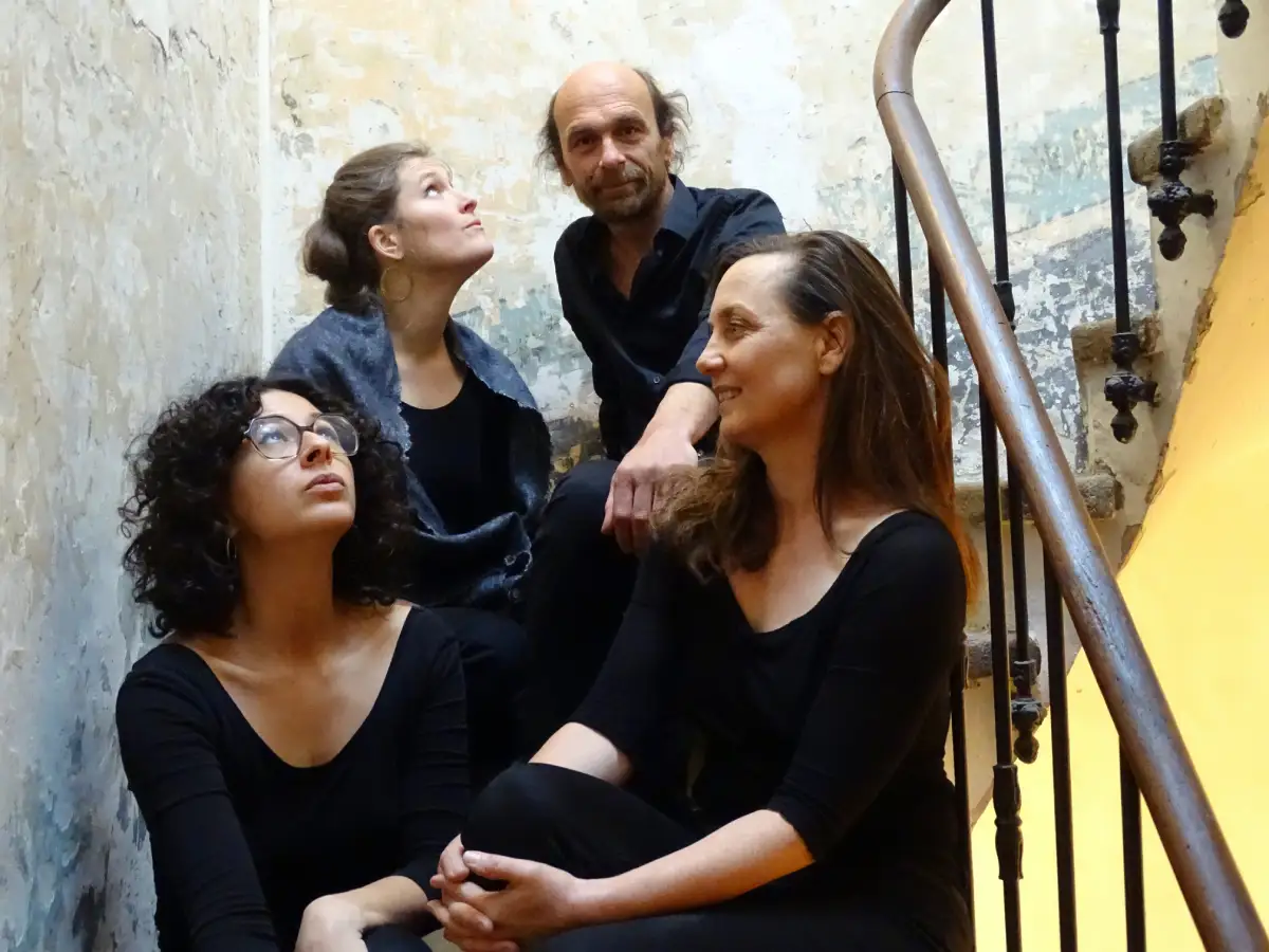 Trois femmes et un homme assis sur un escalier