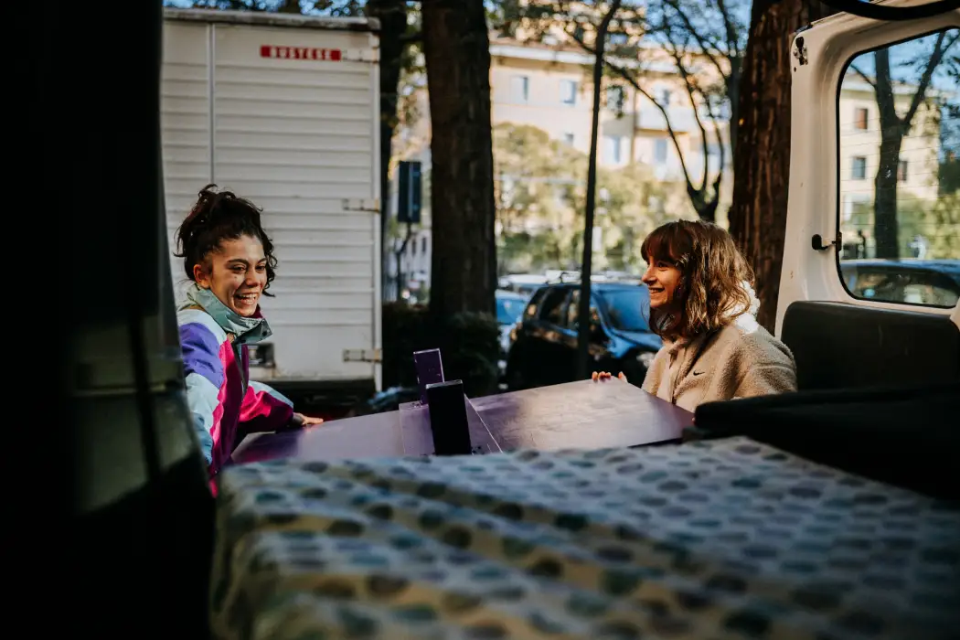 Deux jeunes femmes assises à une table en extérieur