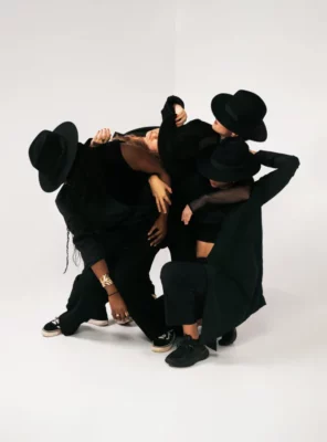 Un groupe de femmes habillées en noir sur fond blanc dans une composition de groupe