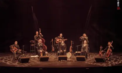 Photo d'un groupe de musiciens et musiciennes sur scène avec leurs instruments