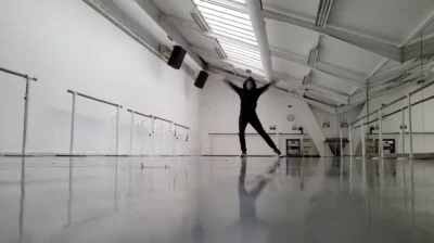 Une femme habillée en noir dans une salle de danse en train de bouger